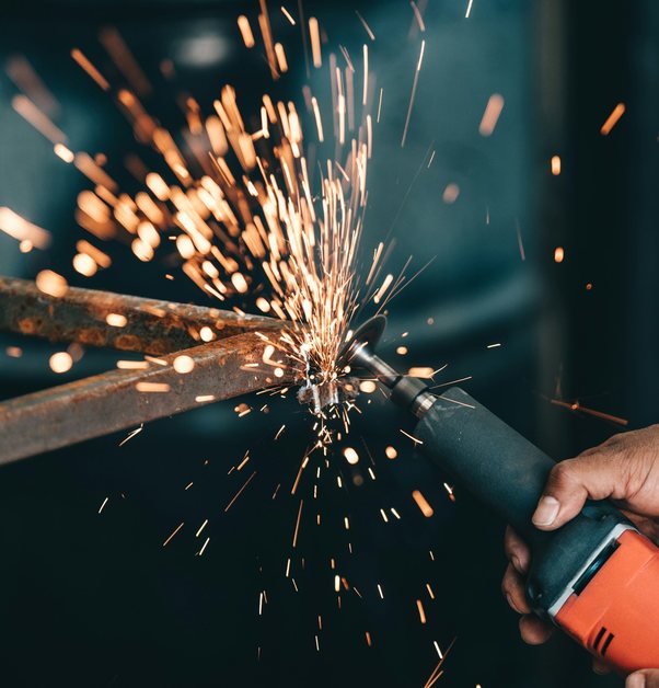 an angle grinder throwing sparks off a steel bar