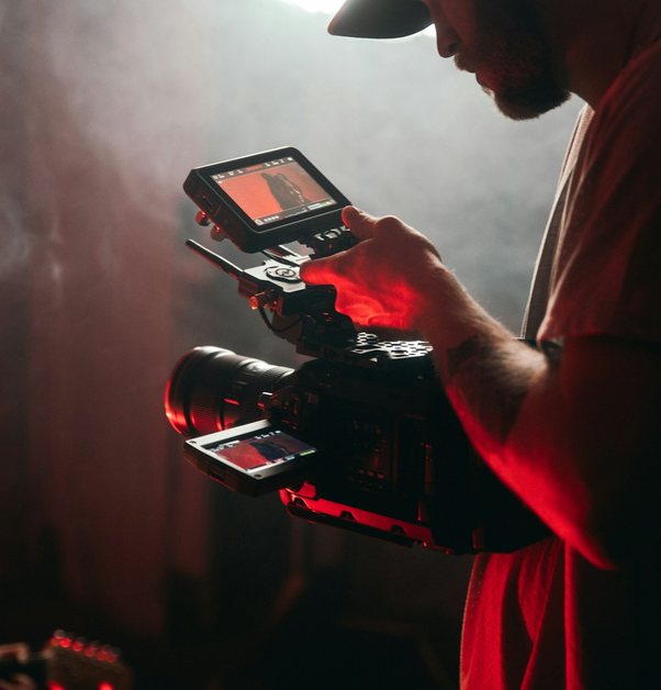 a camera operator holding a rigged cinema camera